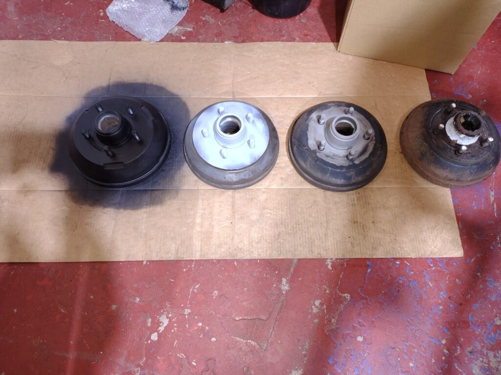 Trailer brake drums showing condition and refurbishment progression